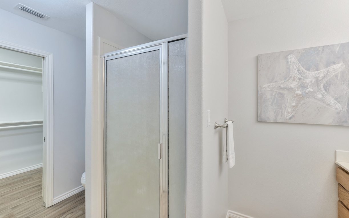 Step into your serene bathroom retreat with modern finishes, ocean-inspired artwork, and soft towels waiting for your arrival.