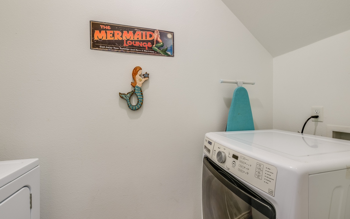 Your private laundry room features full-size washer and dryer with charming mermaid-themed decor and an ironing station.