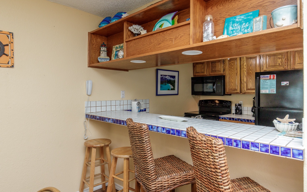 Your coastal kitchen awaits with cheerful blue tile accents, wicker seating, and everything you need for memorable vacation meals.