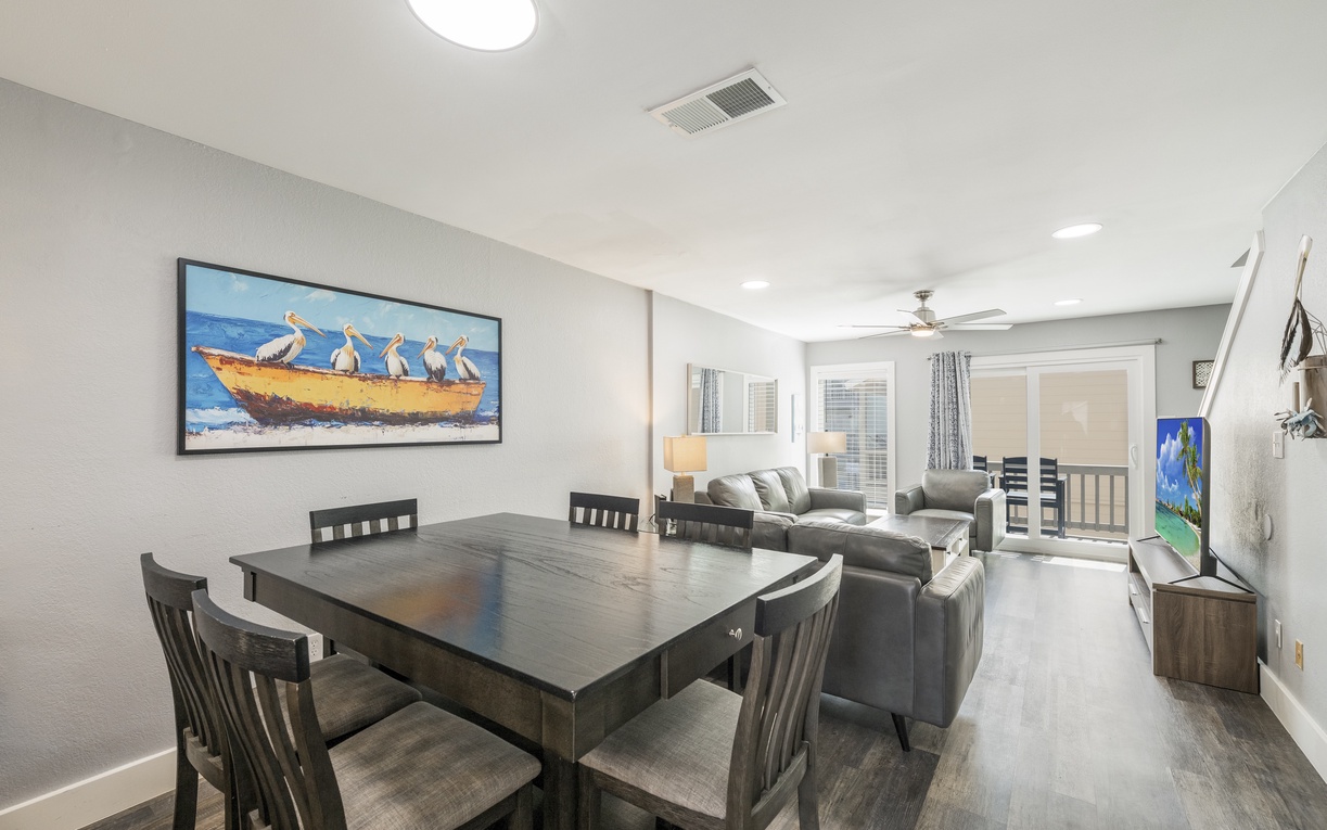 Your spacious open-plan living area invites relaxation with comfortable seating and coastal charm, perfect for memorable gatherings.