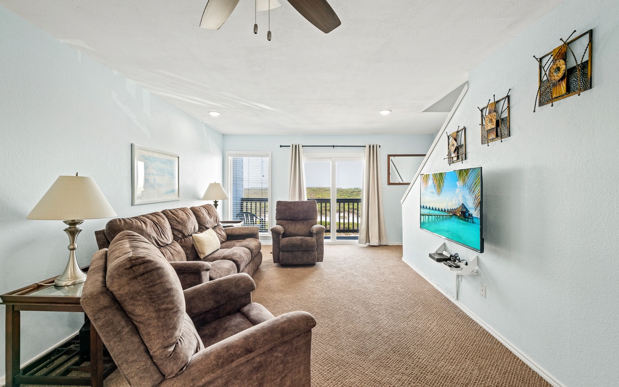 Sink into plush seating and feel the ocean breeze through your private balcony doors. This open living space invites you to relax with coastal views just beyond, perfectly blending comfort and connection to the waterfront.
