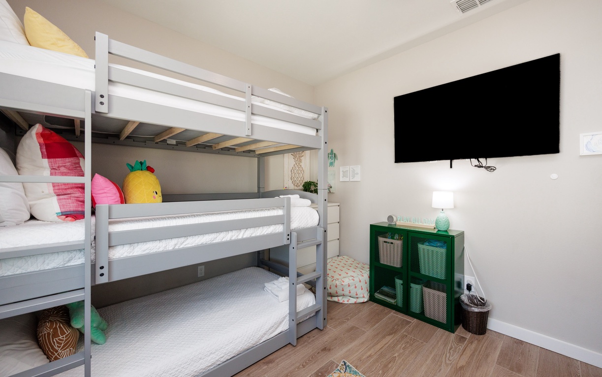 Cozy bunk room where your little ones can drift off to sleep, complete with playful décor and entertainment for bedtime stories.