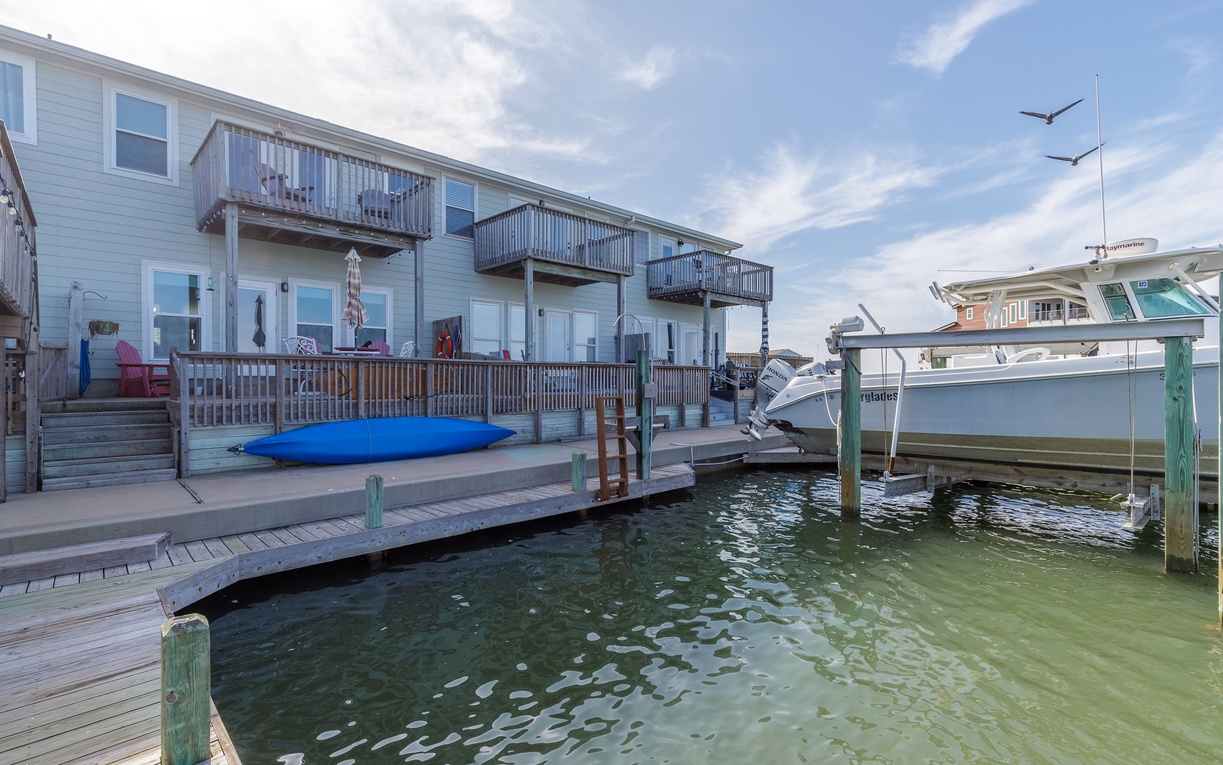 Waterfront property with private dock and boat access, featuring multiple balconies overlooking the marina.