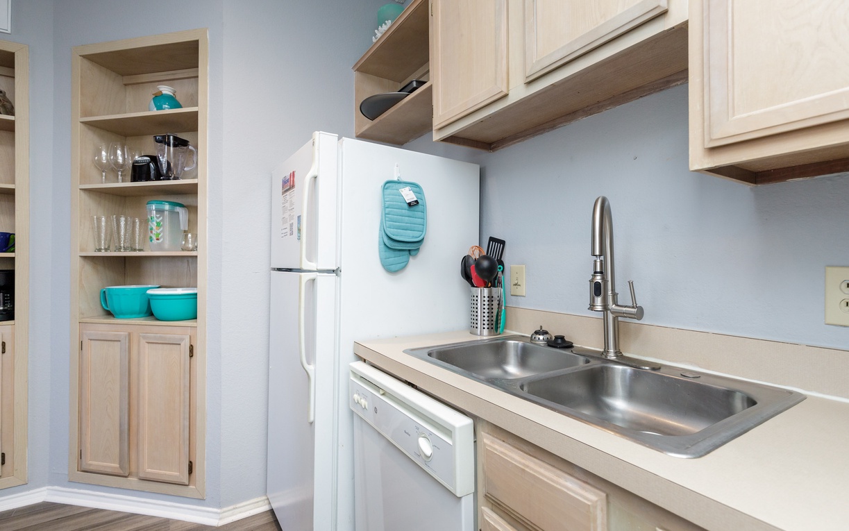 Your fully equipped kitchen awaits with everything you need to create memorable meals, featuring modern appliances and cheerful turquoise accents.