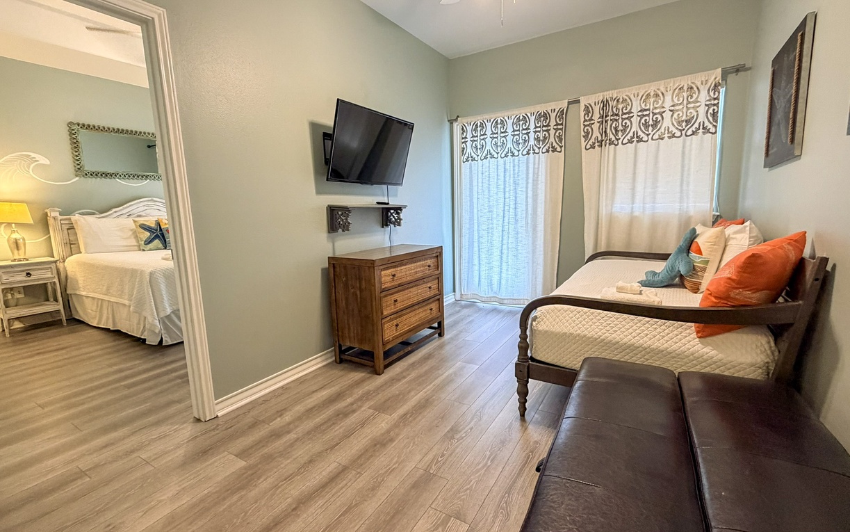 Loft area cross from Master Suite features a cozy daybed with vibrant pillows with warm coastal decor.
