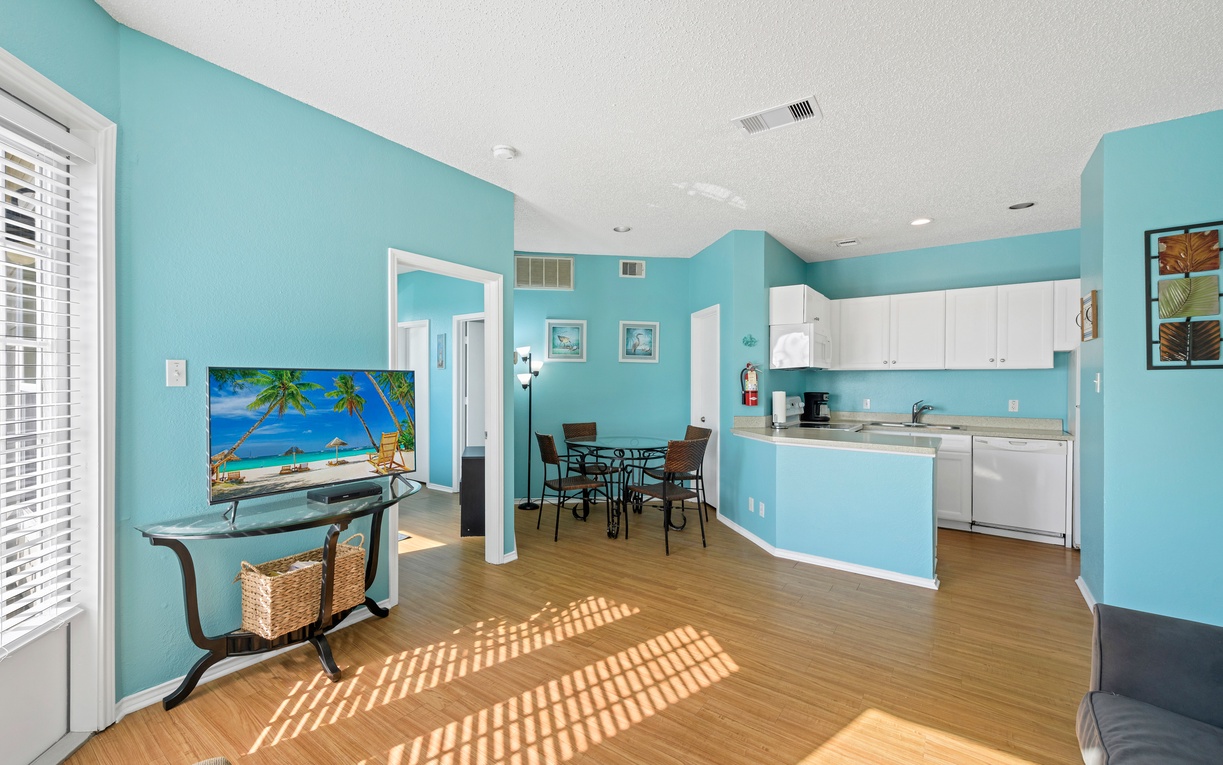 Unwind in your bright, tropical-inspired living space where turquoise walls and warm sunlight create the perfect beach getaway atmosphere.