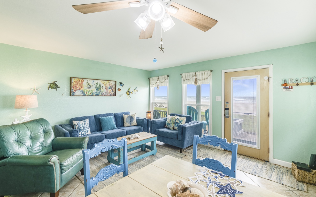 Relax in your ocean-themed living room with comfortable seating and gentle sea breezes flowing through French doors to your private deck.