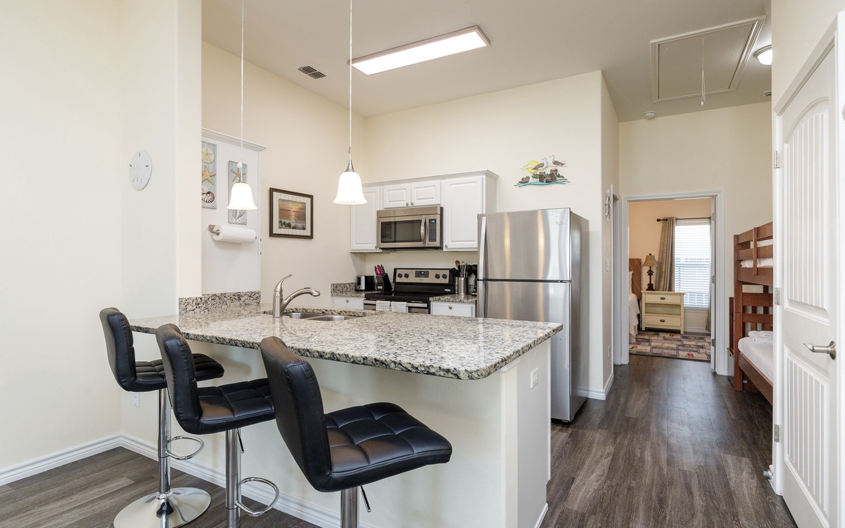 Your modern kitchen features granite countertops, stainless steel appliances, and a breakfast bar perfect for morning coffee or casual meals together.