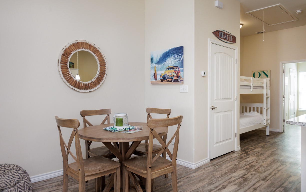Gather around your cozy dining table for morning coffee or evening games, with beach-themed art creating that perfect coastal vibe.