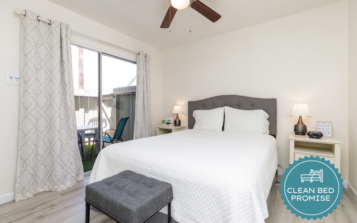 Rest easy in your crisp white linens with soft natural light streaming through your window and a gentle ceiling fan overhead.