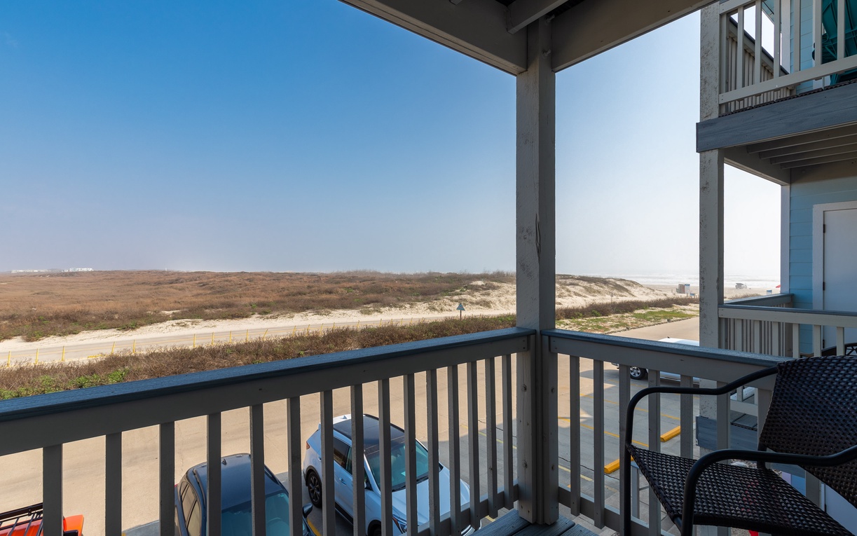 Relax on your private living room balcony overlooking sweeping coastal dunes and endless blue skies—your perfect retreat awaits.
