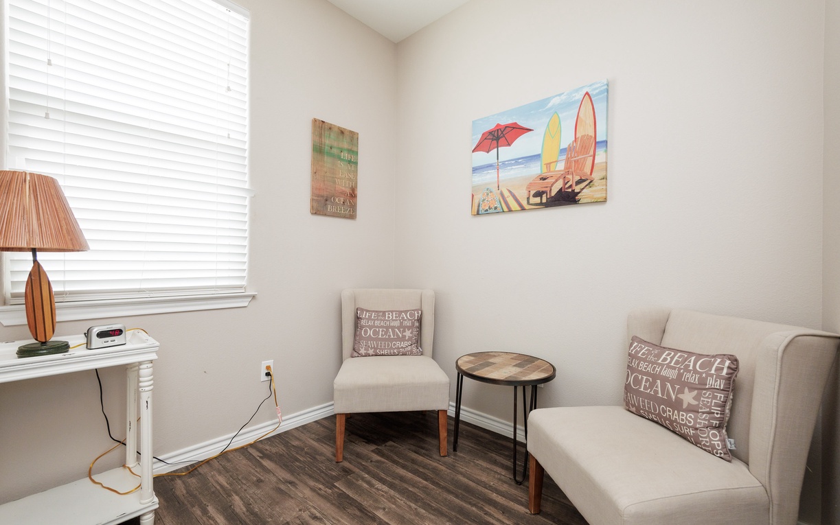 Relax in your cozy seating nook with beach-themed decor, perfect for morning coffee or evening unwinding.