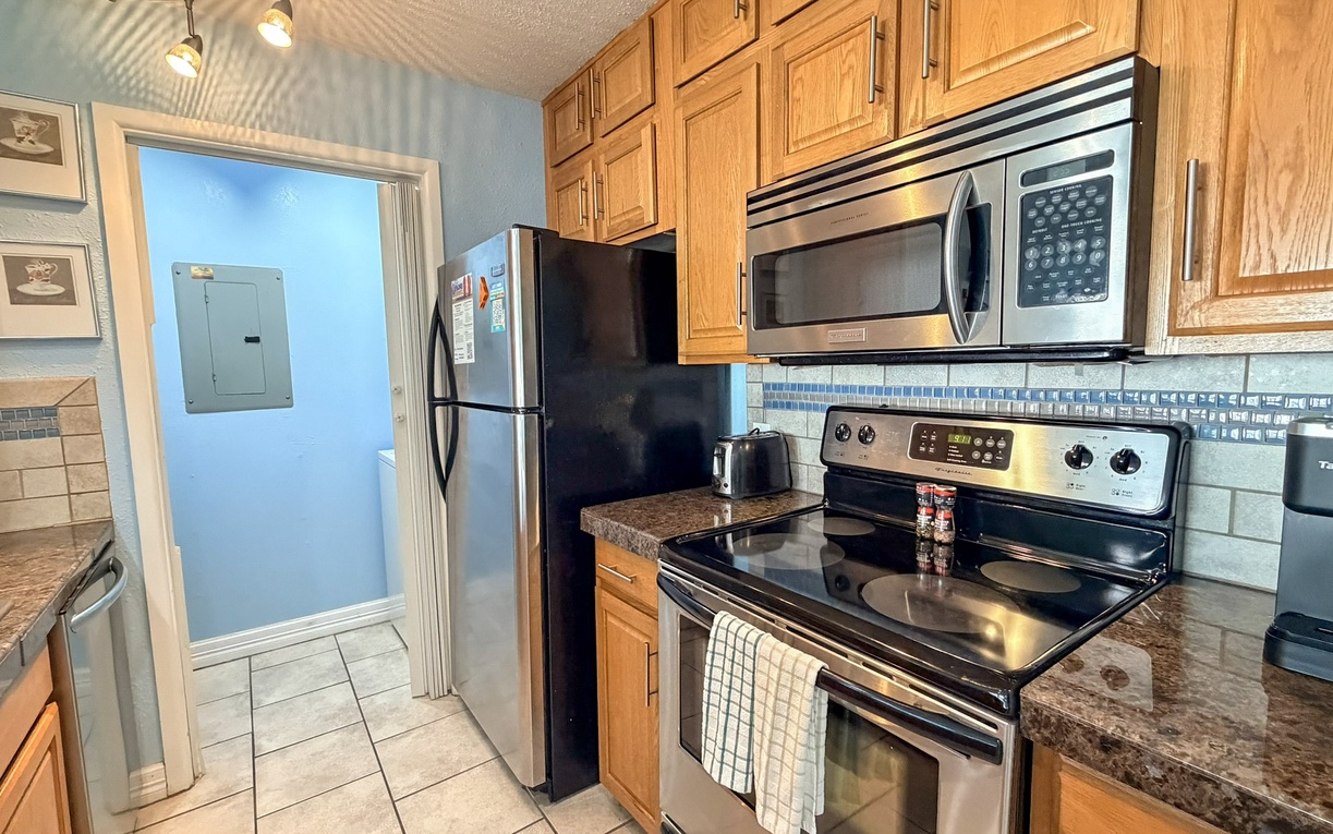 Your fully equipped kitchen features granite counters, stainless appliances, and warm wood cabinetry for preparing delicious home-cooked meals.