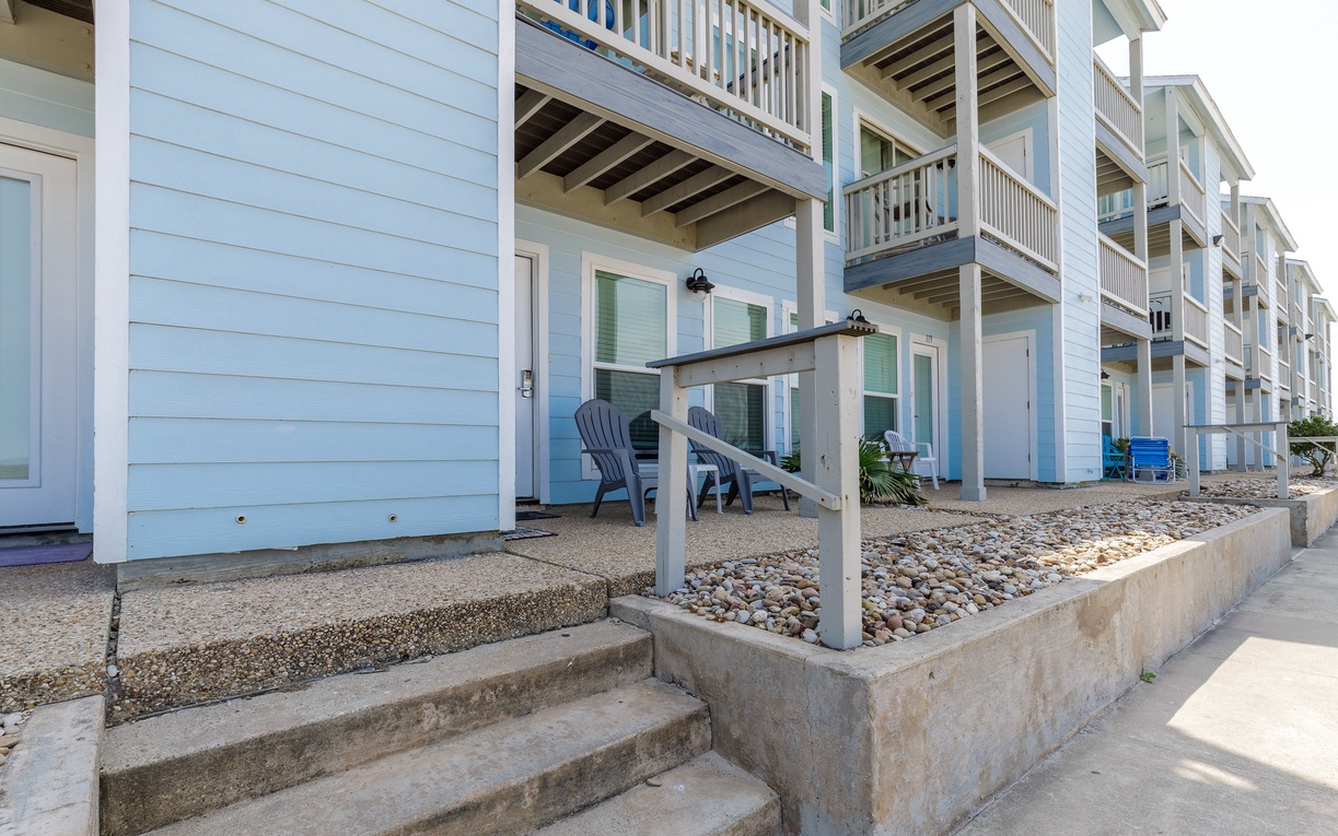Charming coastal building exterior with multiple balconies and traditional architecture in a peaceful residential setting.