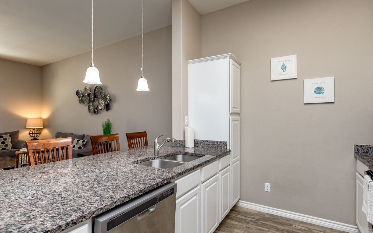 You'll love preparing meals in this modern kitchen with granite counters, white cabinets, and dishwasher, all flowing seamlessly into your dining area.