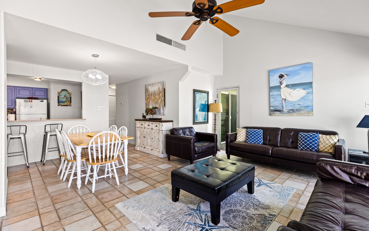 Step into your bright, open living space where coastal charm meets comfort with leather seating, dining table, and kitchen.