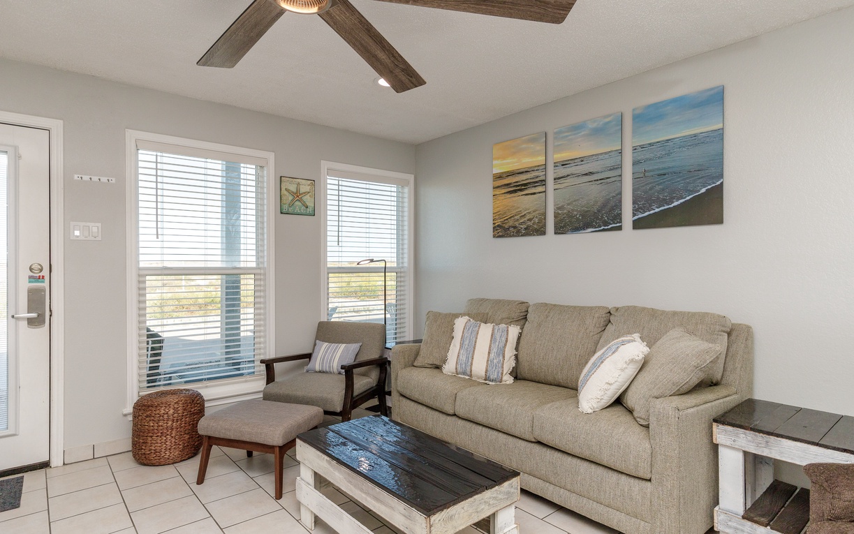 Relax in your coastal-inspired living room where beachy artwork and comfortable seating create the perfect spot to unwind after exploring.