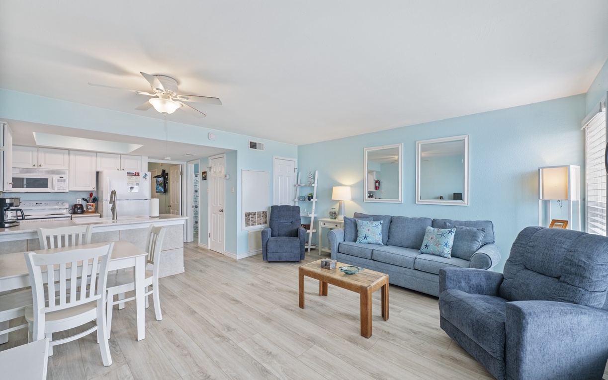 Step into your bright, coastal-inspired living space where soft blue walls and comfortable seating create the perfect atmosphere for relaxation.