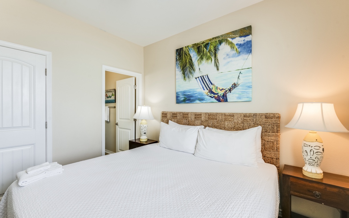 Sink into crisp white linens under tropical artwork that transports you to paradise before you even step outside.