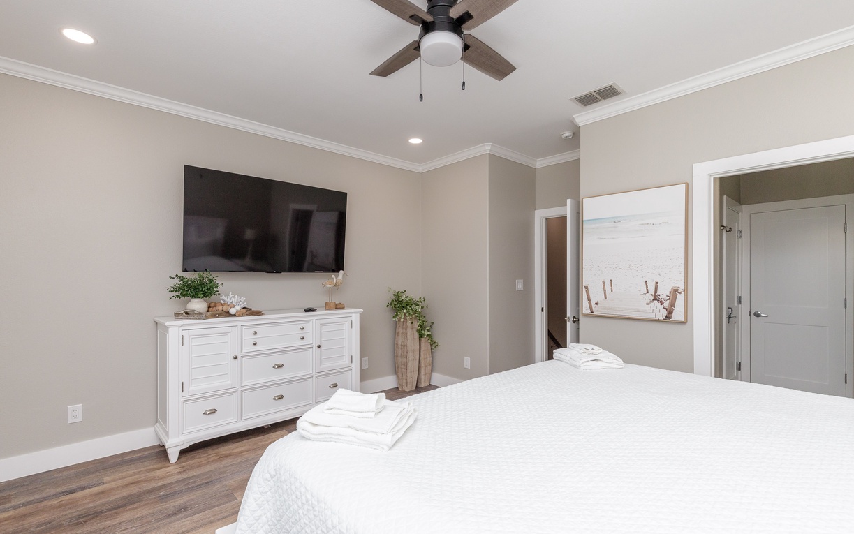 Unwind in your serene bedroom with premium linens, smart TV, and gentle ceiling fan creating the perfect atmosphere for restful nights.