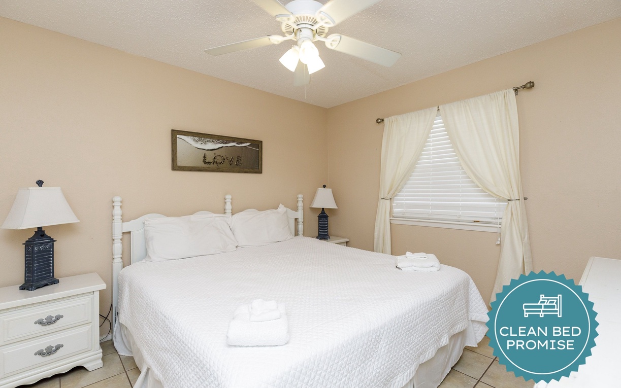 Slip into crisp white linens in your peaceful bedroom, where gentle ceiling fan breezes and soft natural light create the perfect retreat.