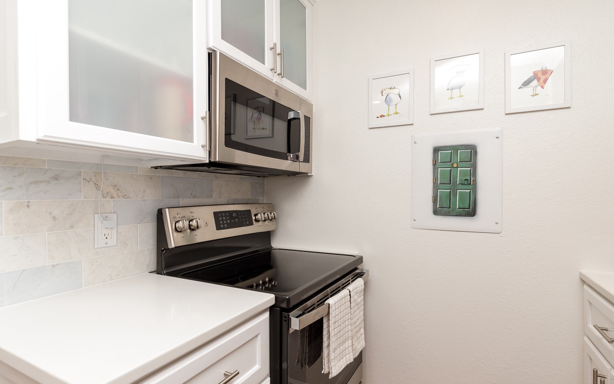 Your fully equipped kitchen features modern stainless steel appliances and elegant white cabinets, perfect for preparing meals during your stay.