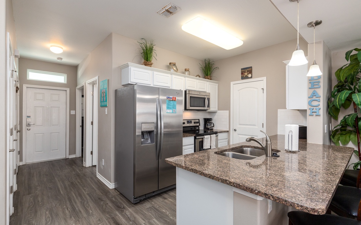 Prepare your favorite meals in this bright, fully equipped kitchen featuring granite countertops, stainless steel appliances, and ample workspace.