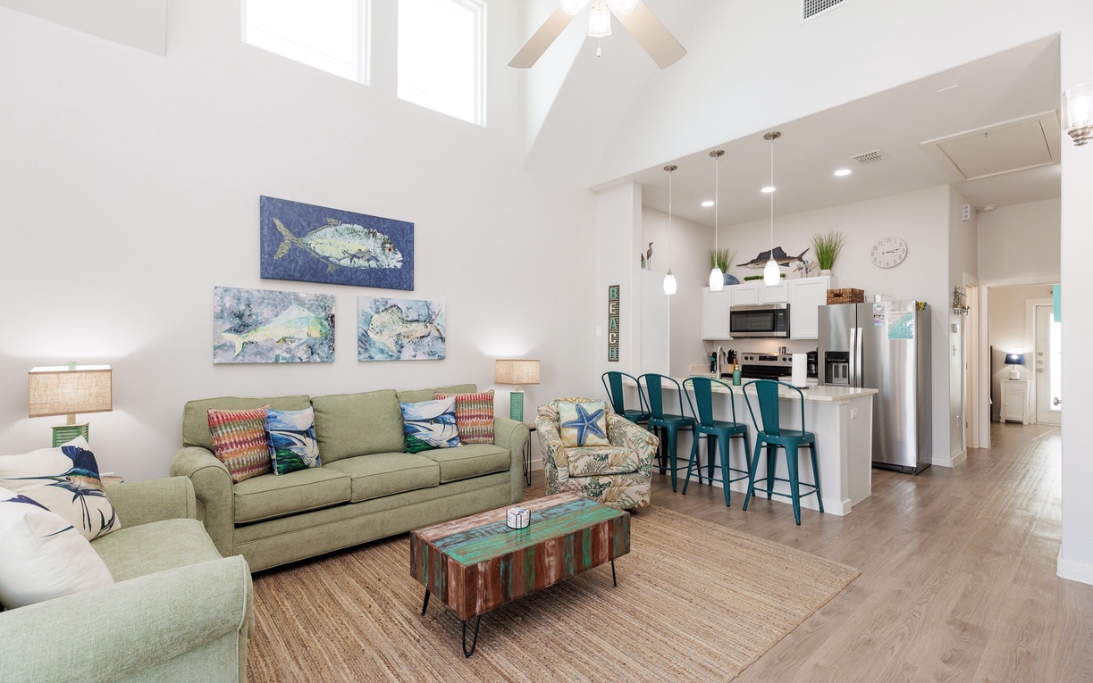 Relax in your bright coastal-themed living space with vaulted ceilings and modern kitchen where you'll love gathering for meals.