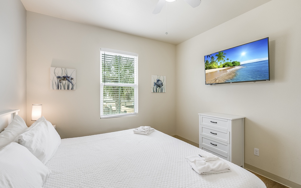 Sink into crisp white linens and enjoy your favorite shows on the wall-mounted TV in this peaceful bedroom retreat.