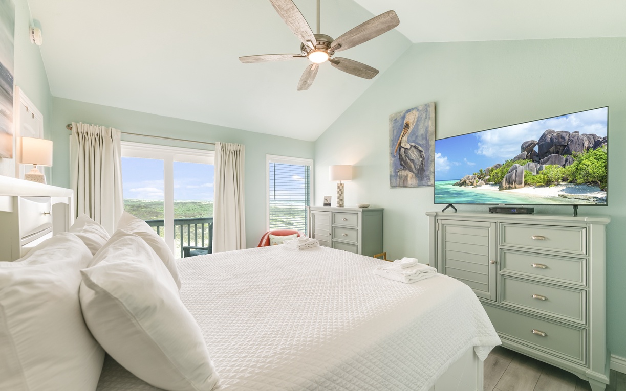 Sink into crisp linens and let the ceiling fan's gentle breeze soothe you after a day exploring. Your private balcony offers peaceful views, while the flat-screen TV awaits your favorite shows.