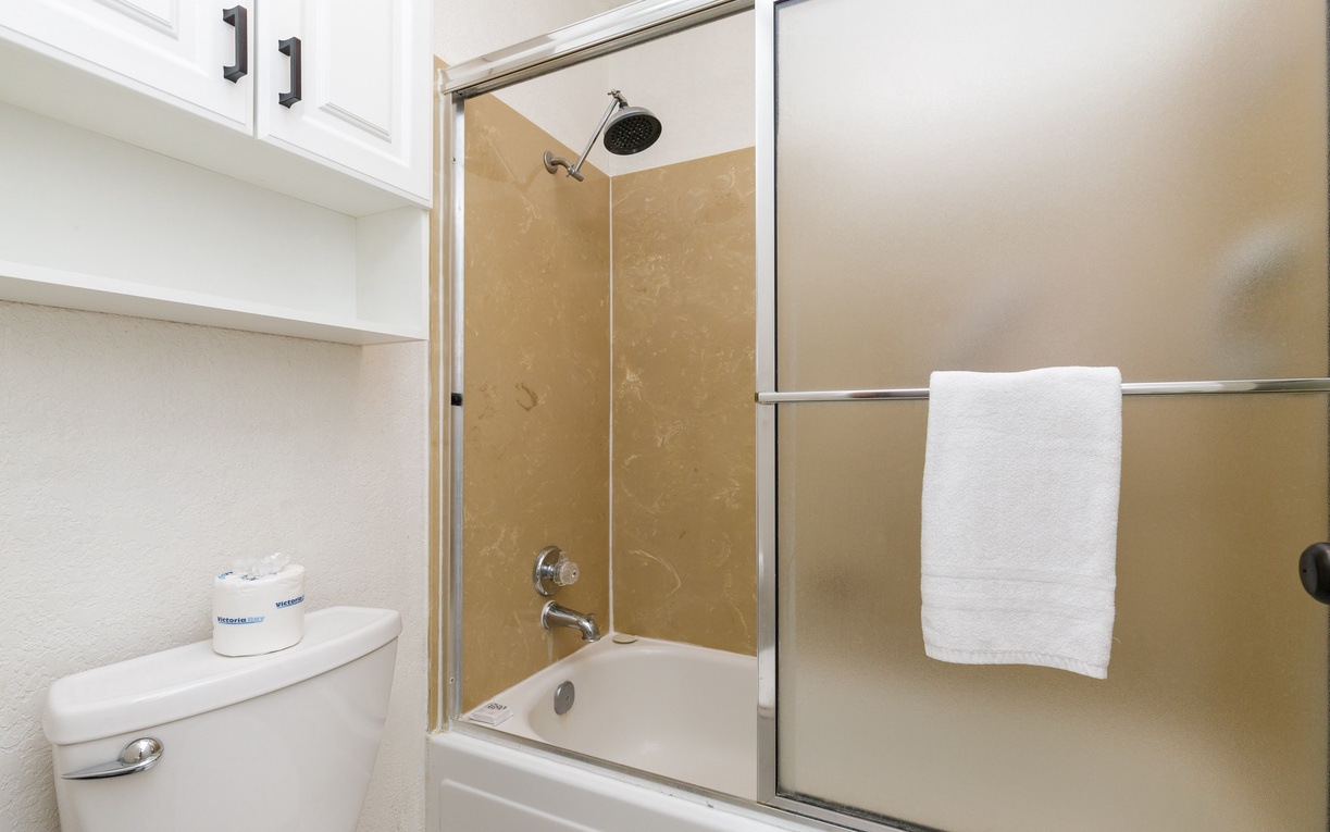 Refresh in your private bathroom with a modern glass-enclosed shower-tub combo and fresh towels awaiting your arrival.
