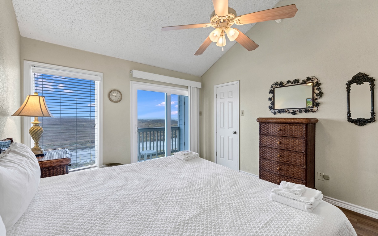 Wake up to breathtaking ocean views from your comfortable bed, with gentle ceiling fan breezes and private balcony access.