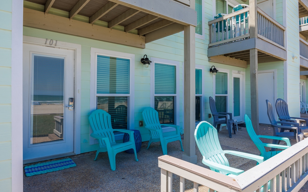 Your covered porch welcomes you with vibrant turquoise Adirondack chairs perfect for morning coffee and evening relaxation.