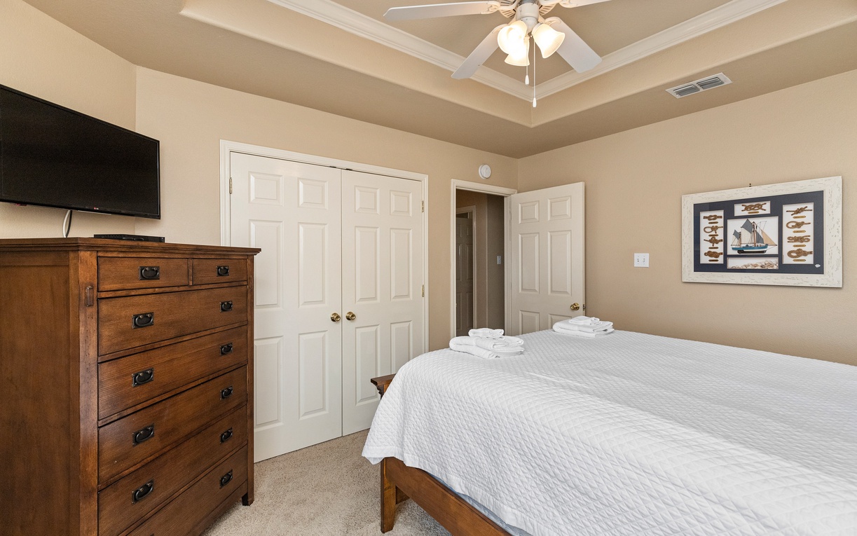 Unwind in your peaceful bedroom featuring cozy linens, warm furnishings, and thoughtful touches like fresh towels awaiting your arrival.