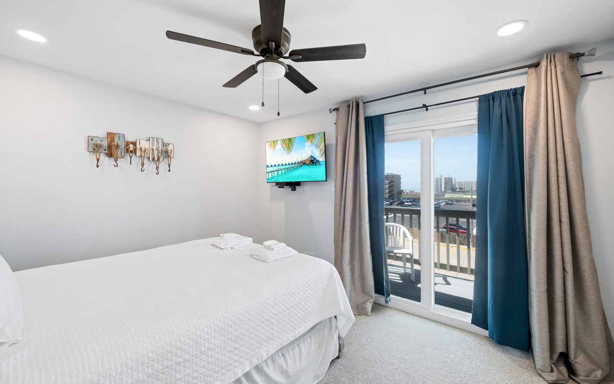 Your peaceful retreat features crisp white linens and a ceiling fan to keep you comfortable, while glass doors open to your own private balcony with city views.