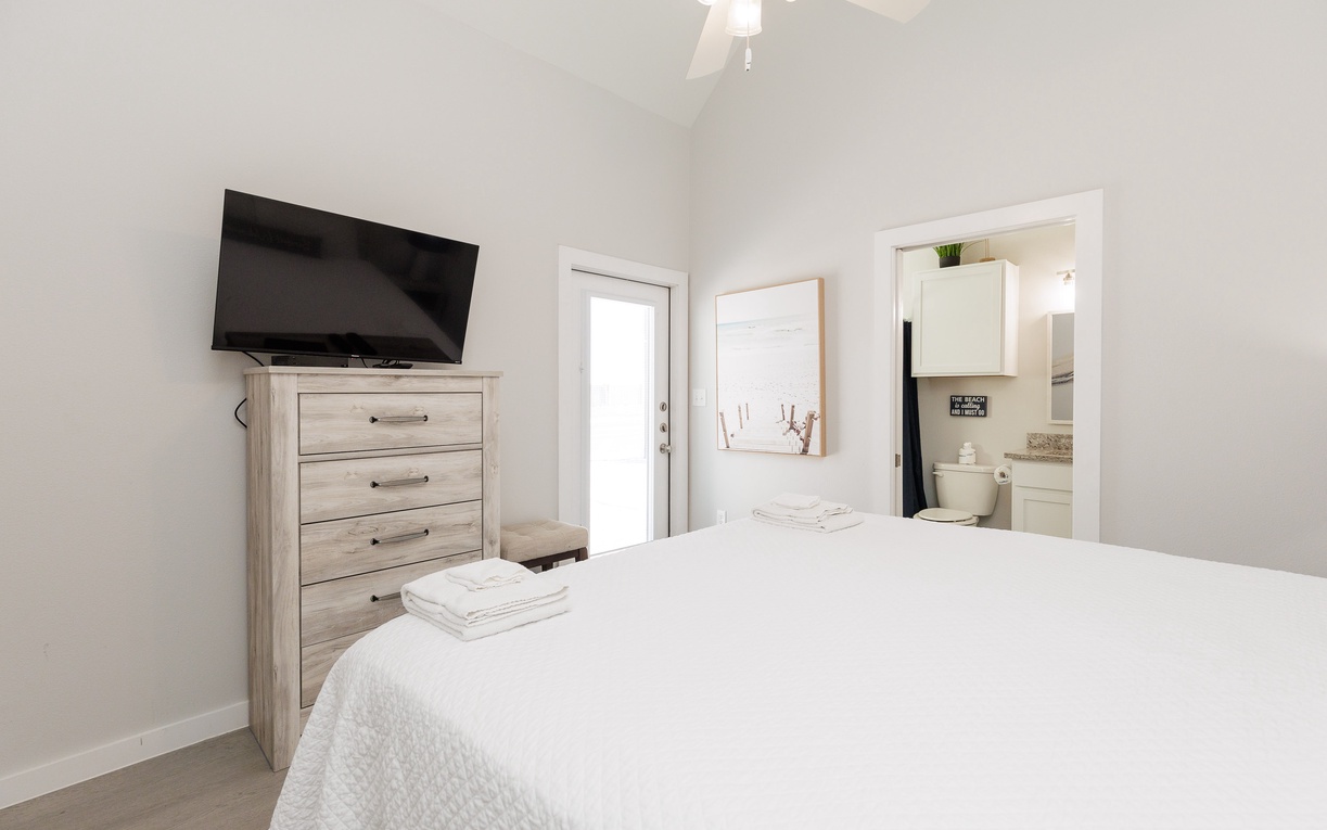 Your bright bedroom features a comfortable bed with fresh linens, entertainment center, and convenient en-suite bathroom access.