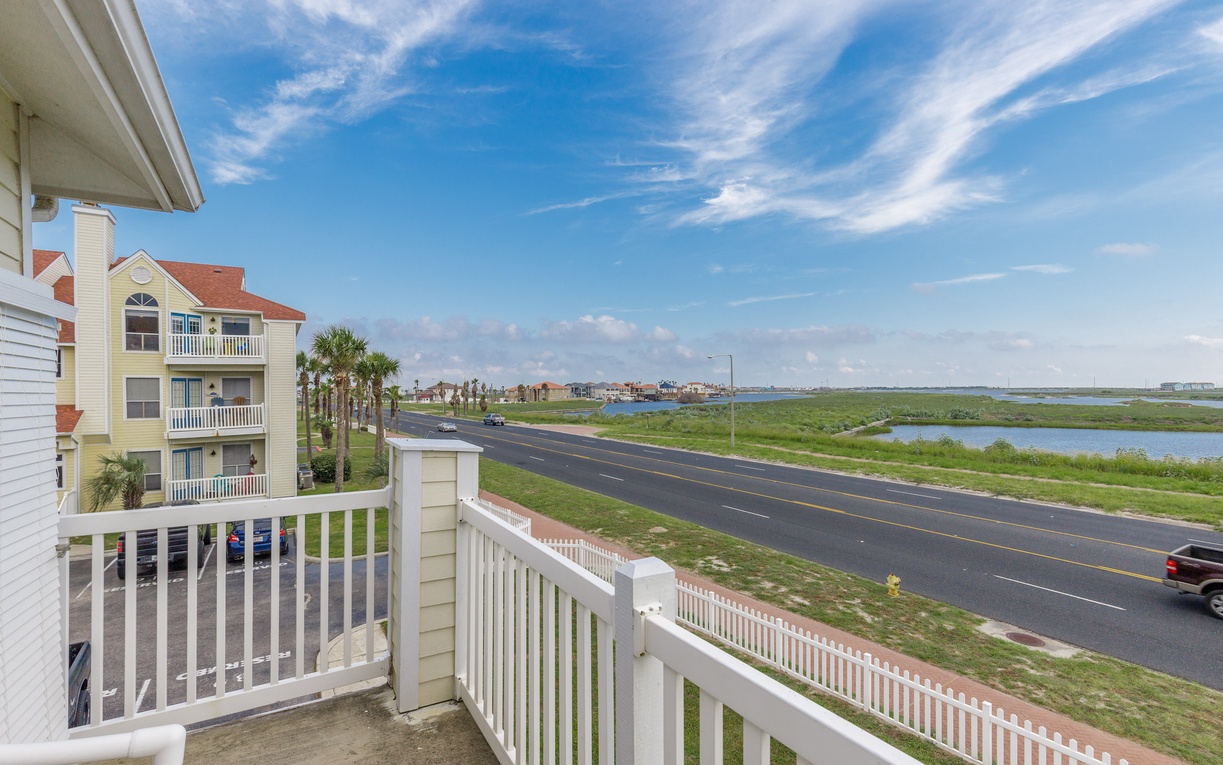 Coastal balcony overlooking scenic waterways and neighboring properties in a peaceful waterfront community.