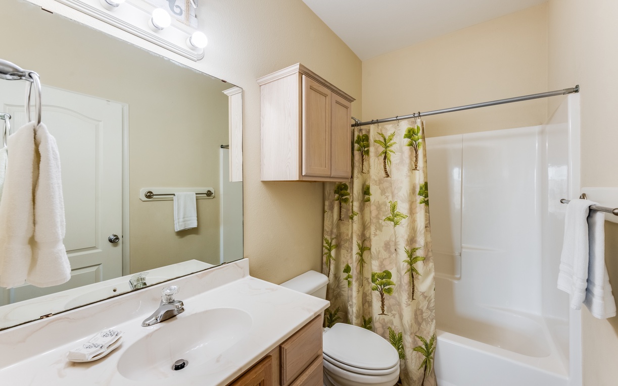 Your private bathroom features a relaxing tub-shower combo, fresh towels, and tropical-themed touches that make each day feel like a vacation.