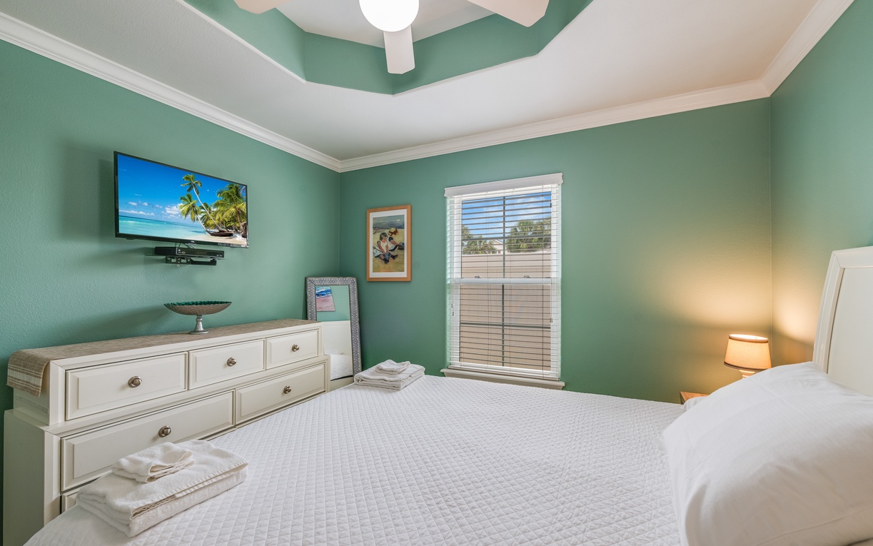Drift off to peaceful dreams in this serene bedroom, where soothing sea-green walls and crisp linens create your perfect retreat.