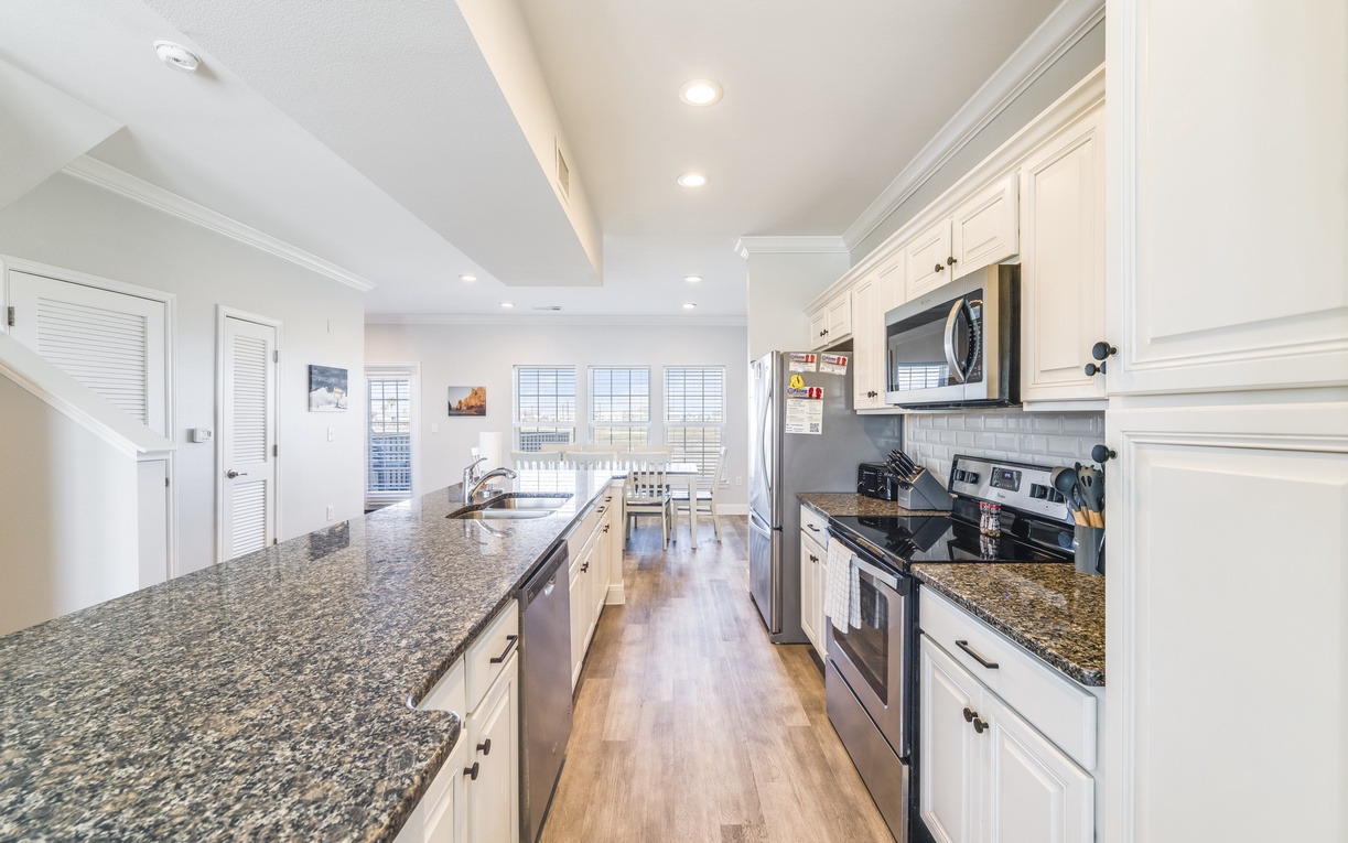 Step into your spacious gourmet kitchen with gleaming granite countertops, crisp white cabinets, and everything you need to create memorable meals.
