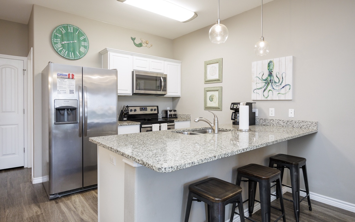 Your fully equipped kitchen features granite countertops, stainless steel appliances, and a breakfast bar perfect for morning coffee or casual meals.