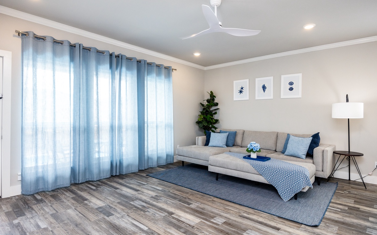 Sink into this airy living room where soft blue accents and natural light create your perfect retreat for relaxing after exploring.