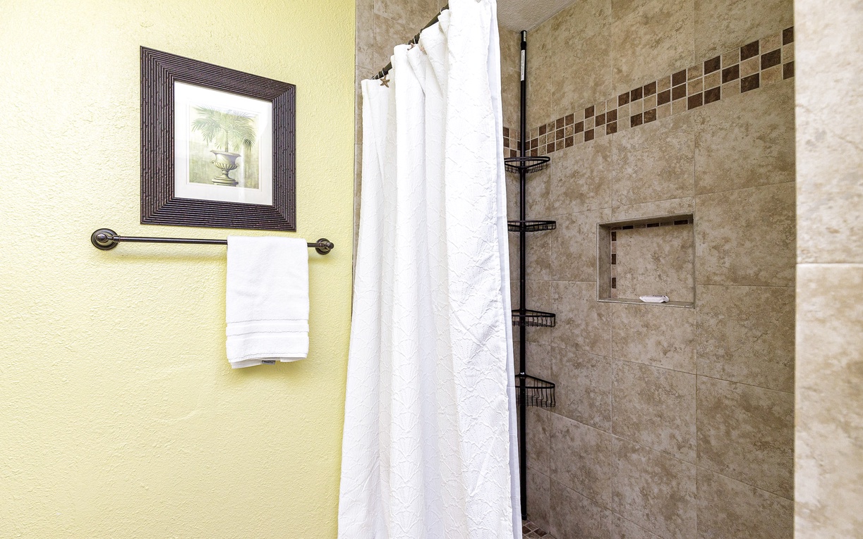 Step into your private spa-like shower with elegant stone tiles and convenient built-in storage for all your essentials.