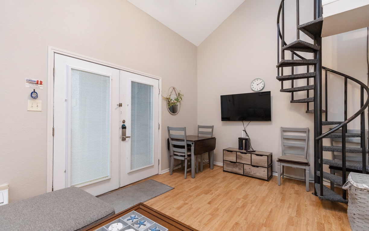 Your cozy living space features warm hardwood floors, a spiral staircase leading to your loft, and a dining nook perfect for morning coffee.