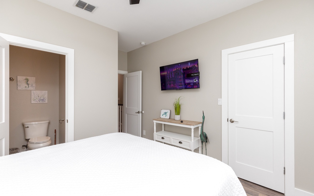 Your cozy bedroom features crisp white linens, modern amenities, and thoughtful touches like fresh greenery for a peaceful night's rest.