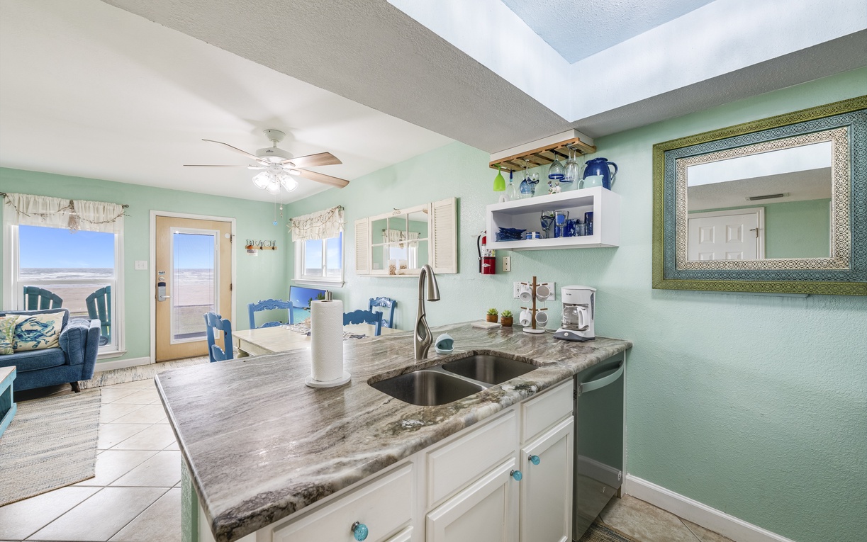 Your fully equipped kitchen opens to coastal views, with granite counters and ocean-themed touches creating the perfect beachside cooking space.