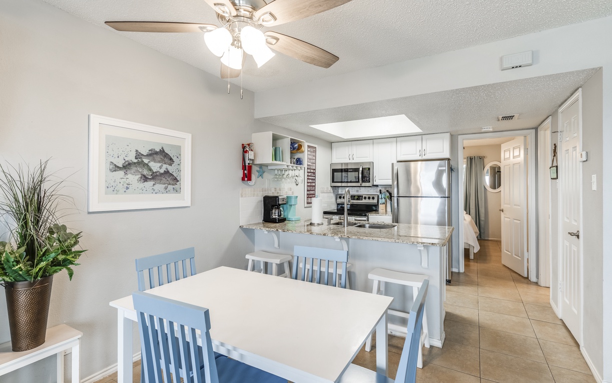 Gather around your bright dining table, where the open kitchen invites easy meal prep and the ceiling fan keeps you cool.