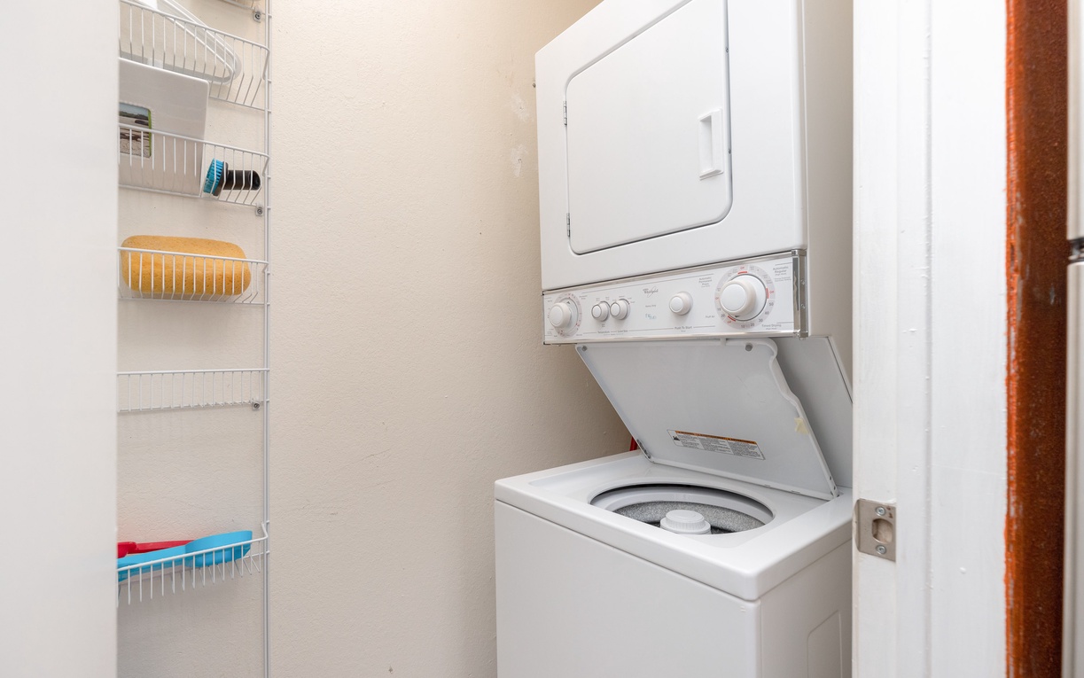Your in-unit laundry closet features a stacked washer and dryer with organized wire shelving for all your vacation essentials.