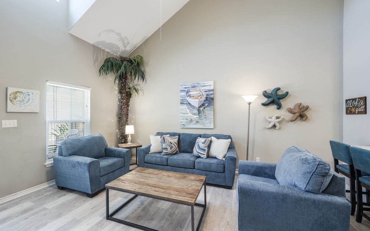 Sink into plush blue sofas in this light-filled living area, where coastal charm meets comfort. Soaring ceilings and beachy décor create the perfect spot for your group to unwind together.