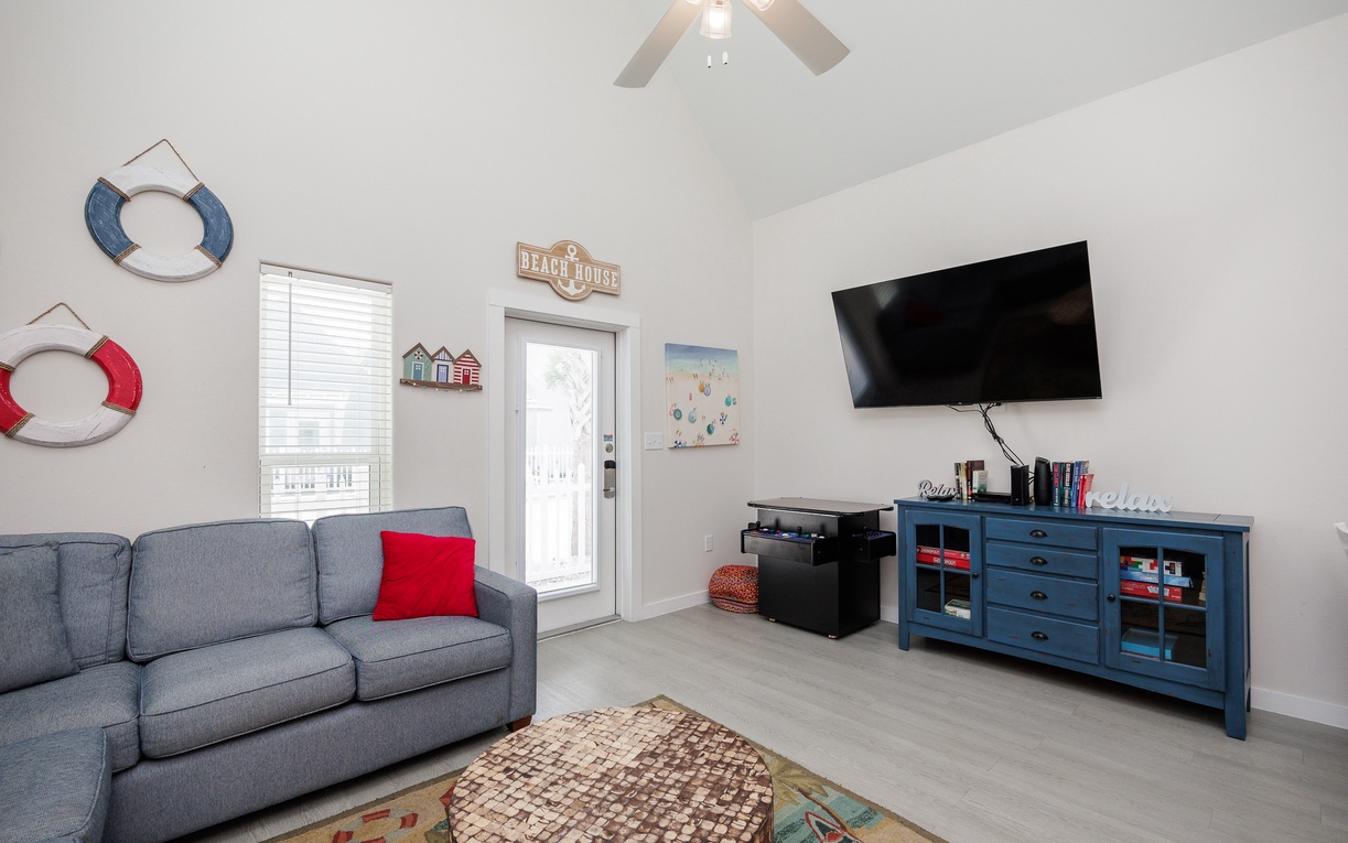 Relax in your charming coastal-themed living room with comfortable seating, entertainment center, and playful nautical touches throughout.